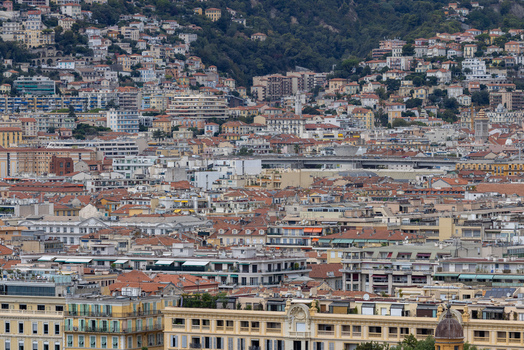 Aerial view of the dense urban landscape of Nice featuring terracotta rooftops and historic architecture nestled against the hillside in Nice Provence Alpes Cote d Azur France. Aerial view of the dense urban landscape of Nice featuring terracotta rooftops and historic architecture nestled against the hillside in Nice Provence Alpes Cote d Azur France.