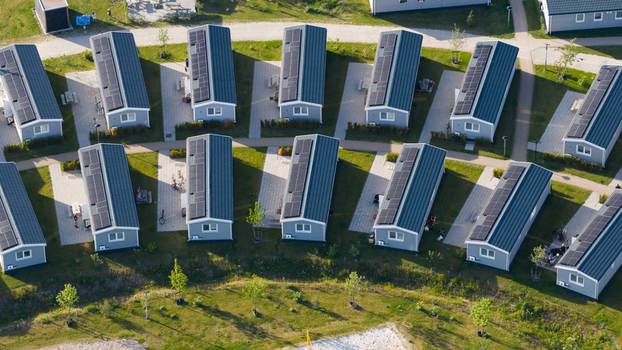 Aerial view of rows of modern holiday houses with solar panels on their roofs surrounded by green lawns and paved walkways in a holiday park in Venlo Limburg Netherlands. Aerial view of rows of modern holiday houses with solar panels on their roofs surrounded by green lawns and paved walkways in a holiday park in Venlo Limburg Netherlands.