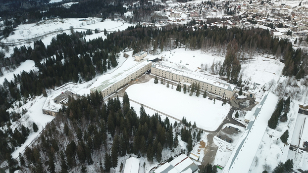 Aerial view of Le Fort des Rousses with its historic stone buildings and snow covered courtyard surrounded by dense pine forests in Les Rousses Bourgogne Franche Comte France.