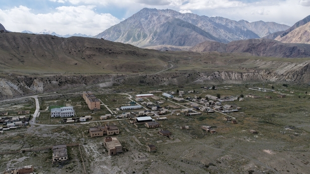 Aerial view of the remote settlement of Engilchek near the Engilchek Glacier featuring scattered buildings and rugged mountain terrain in Ak Su Issyk Kul Region Kyrgyzstan. Aerial view of the remote settlement of Engilchek near the Engilchek Glacier featuring scattered buildings and rugged mountain terrain in Ak Su Issyk Kul Region Kyrgyzstan.