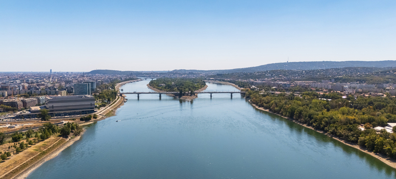 Aerial view of the Danube River splitting around Margaret Island and Arpad Bridge with the Buda and Pest cityscape of Budapest Hungary under a clear summer sky. Aerial view of the Danube River splitting around Margaret Island and Arpad Bridge with the Buda and Pest cityscape of Budapest Hungary under a clear summer sky.