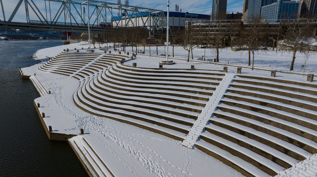 Aerial view of the snow covered Serpentine Wall at Smale Riverfront Park along the Ohio River with the city skyline and arena in Cincinnati Ohio United States. Aerial view of the snow covered Serpentine Wall at Smale Riverfront Park along the Ohio River with the city skyline and arena in Cincinnati Ohio United States.