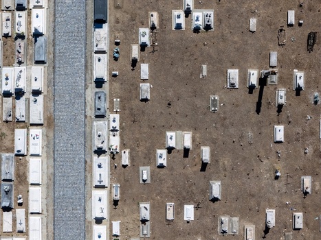 Aerial view of the cemetery in Evora with rows of white stone graves and a cobblestone pathway set against dry earth in Evora Evora District Portugal. Aerial view of the cemetery in Evora with rows of white stone graves and a cobblestone pathway set against dry earth in Evora Evora District Portugal.