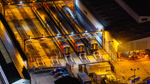 Aerial view of three trains parked at a railway depot illuminated by bright artificial lights at night in Salisbury England United Kingdom. Aerial view of three trains parked at a railway depot illuminated by bright artificial lights at night in Salisbury England United Kingdom.