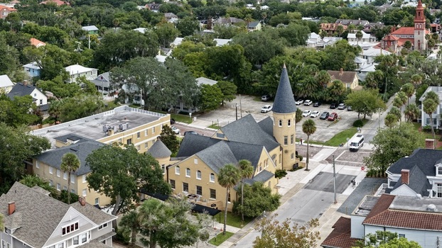 Aerial view of the historic Ancient City Baptist Church surrounded by lush trees and residential rooftops in St. Augustine Florida United States. Aerial view of the historic Ancient City Baptist Church surrounded by lush trees and residential rooftops in St. Augustine Florida United States.
