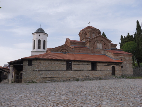 View of the Church of the Virgin Mary Peribleptos with its distinctive red tiled roof stone walls and bell tower set against a cloudy sky in Ohrid Municipality of Ohrid North Macedonia. View of the Church of the Virgin Mary Peribleptos with its distinctive red tiled roof stone walls and bell tower set against a cloudy sky in Ohrid Municipality of Ohrid North Macedonia.