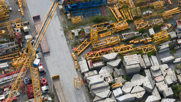 Aerial view of Feluy de Parc Industriel showing yellow crane components steel lattice structures and stacked concrete blocks in a storage yard in Seneffe Region wallonne Belgium.