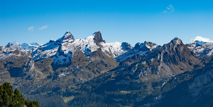 Aerial view of the snow capped peaks of the Swiss Alps under a clear blue sky in Airolo Ticino Switzerland. Aerial view of the snow capped peaks of the Swiss Alps under a clear blue sky in Airolo Ticino Switzerland.