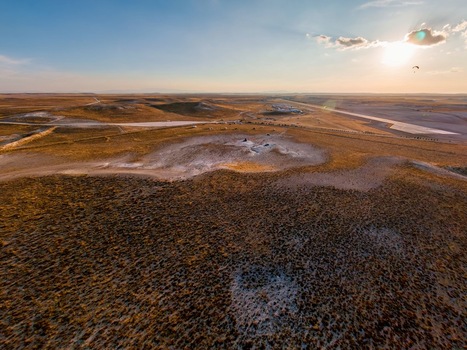 Aerial view of the arid landscape of Sivrihisar featuring rolling hills dry terrain and a paraglider in the distance under a golden hour sky in Sivrihisar Eskisehir Turkey. Aerial view of the arid landscape of Sivrihisar featuring rolling hills dry terrain and a paraglider in the distance under a golden hour sky in Sivrihisar Eskisehir Turkey.