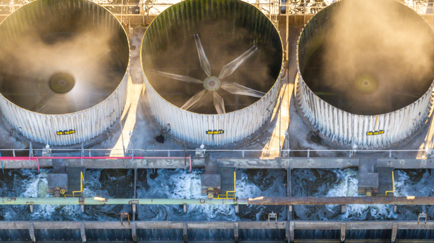 Aerial view of industrial cooling towers at a petrochemical complex with steam rising and water flowing in Santo Andre State of Sao Paulo Brazil.