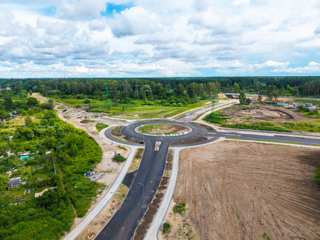 Aerial view of the newly constructed roundabout for the Southern Bridge project featuring fresh asphalt and surrounding green landscape in Riga Latvia. Aerial view of the newly constructed roundabout for the Southern Bridge project featuring fresh asphalt and surrounding green landscape in Riga Latvia.