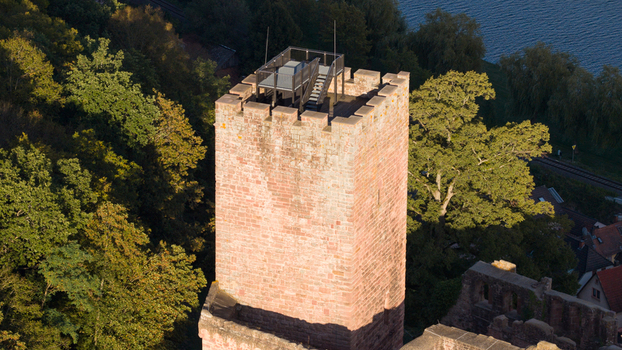 Aerial view of the historic Henneburg castle tower with its red sandstone walls and observation deck surrounded by lush forest near the river Main in Stadtprozelten Bayern Germany.