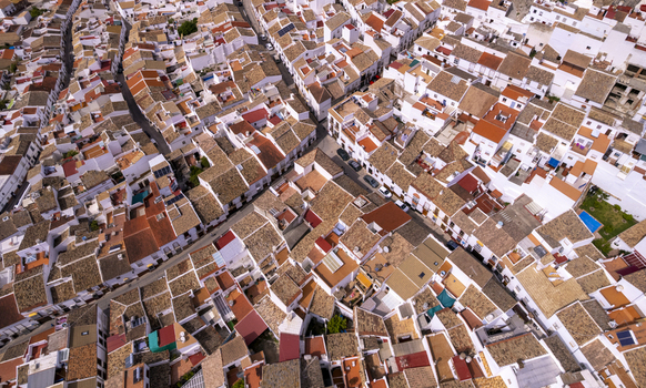 Aerial view of the historic town of Olvera showcasing dense clusters of traditional white washed houses with terracotta tiled roofs and narrow winding streets in Olvera Andalusia Spain. Aerial view of the historic town of Olvera showcasing dense clusters of traditional white washed houses with terracotta tiled roofs and narrow winding streets in Olvera Andalusia Spain.
