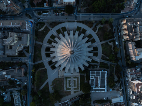 Aerial view of the Sanctuary of Our Lady of Tears featuring its distinctive circular concrete architecture and surrounding city streets at dusk in Syracuse Sicily Italy. Aerial view of the Sanctuary of Our Lady of Tears featuring its distinctive circular concrete architecture and surrounding city streets at dusk in Syracuse Sicily Italy.