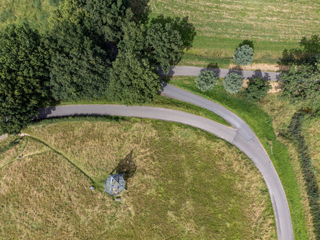 Aerial view of a watchtower standing in a field of golden grass at the edge of a forest where roads converge Oijen Noord Brabant Netherlands. Aerial view of a watchtower standing in a field of golden grass at the edge of a forest where roads converge Oijen Noord Brabant Netherlands.