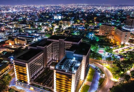 Aerial view of a modern office complex illuminated at night surrounded by the sprawling urban landscape of Accra Ghana. Aerial view of a modern office complex illuminated at night surrounded by the sprawling urban landscape of Accra Ghana.