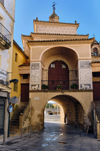 Plasencia Spain 03 December 2025 View of the historic Puerta de Trujillo gate and the Ermita de la Salud chapel with its ornate stone facade and bell tower. Plasencia Spain 03 December 2025 View of the historic Puerta de Trujillo gate and the Ermita de la Salud chapel with its ornate stone facade and bell tower.
