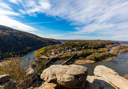 Harpers Ferry West Virginia United States 16 November 2019 Aerial view of Harpers Ferry at the river confluence with historic buildings a bridge and autumn foliage. Harpers Ferry West Virginia United States 16 November 2019 Aerial view of Harpers Ferry at the river confluence with historic buildings a bridge and autumn foliage.