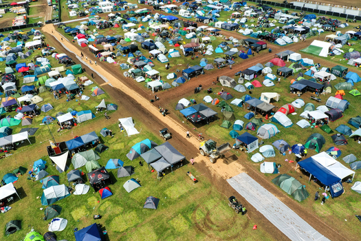 Aerial view of the Open Beatz Festival campsite with numerous colorful tents and people walking along dirt paths Herzogenaurach Bavaria Germany. Aerial view of the Open Beatz Festival campsite with numerous colorful tents and people walking along dirt paths Herzogenaurach Bavaria Germany.