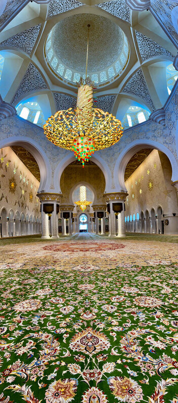 Abu Dhabi United Arab Emirates 15 October 2023 View of the ornate carpet and large golden chandelier inside the Sheikh Zayed Grand Mosque featuring intricate ceiling patterns.