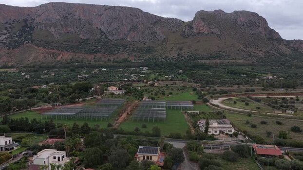 Aerial view of greenhouse frames and a house in Terrasini Italy.