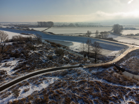 Aerial view of a snow dusted landscape where the serene frozen Vlietberg contrasts with the rugged textures of Tiengeboden Ooij Gelderland Netherlands. Aerial view of a snow dusted landscape where the serene frozen Vlietberg contrasts with the rugged textures of Tiengeboden Ooij Gelderland Netherlands.