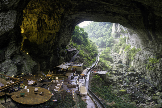 Guiyang Guizhou China 24 June 2026 Aerial view of the Xiuwen County cave entrance featuring a wooden deck restaurant a winding walkway and a rocky gorge. Guiyang Guizhou China 24 June 2026 Aerial view of the Xiuwen County cave entrance featuring a wooden deck restaurant a winding walkway and a rocky gorge.