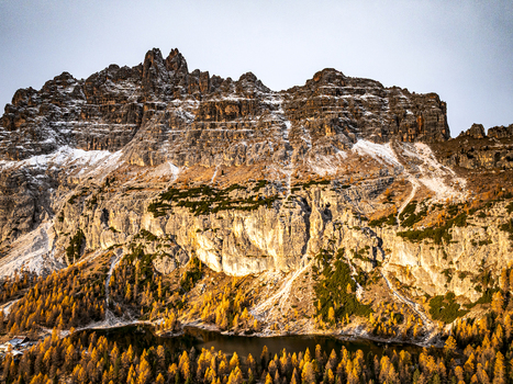 Aerial view of rugged Croda da Lago layered with snow and bathed in golden light. Federa Cortina d Ampezzo Veneto Italy.