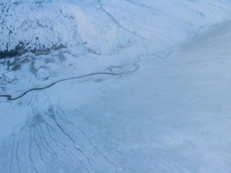 Aerial view of Babusar Pass with a winding river flowing through the snow covered mountain landscape in Babusar KPK Pakistan.