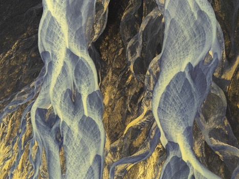 Aerial view of the intricate patterns of a braided glacial river flowing through dark volcanic sediment in Hallgeirseyjarvegur Rangarthing eystra Iceland. Aerial view of the intricate patterns of a braided glacial river flowing through dark volcanic sediment in Hallgeirseyjarvegur Rangarthing eystra Iceland.