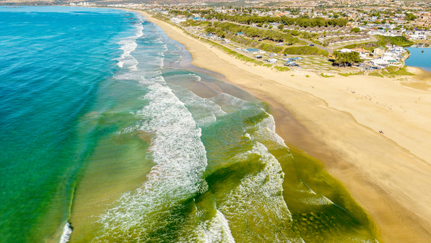 Aerial view of Hartenbos beach with turquoise ocean waves golden sand and coastal houses in Mossel Bay Western Cape South Africa. Aerial view of Hartenbos beach with turquoise ocean waves golden sand and coastal houses in Mossel Bay Western Cape South Africa.