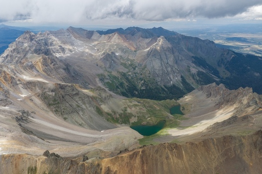 Aerial view of Mount Sneffels and the rugged peaks of the San Juan Mountains featuring the alpine lakes of Yankee Boy Basin Ouray County Colorado United States. Aerial view of Mount Sneffels and the rugged peaks of the San Juan Mountains featuring the alpine lakes of Yankee Boy Basin Ouray County Colorado United States.