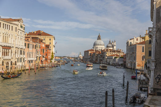Venice Italy 21 September 2026 View of the Grand Canal with the Basilica di Santa Maria della Salute in the background historic buildings boats on the water and blue sky. Venice Italy 21 September 2026 View of the Grand Canal with the Basilica di Santa Maria della Salute in the background historic buildings boats on the water and blue sky.