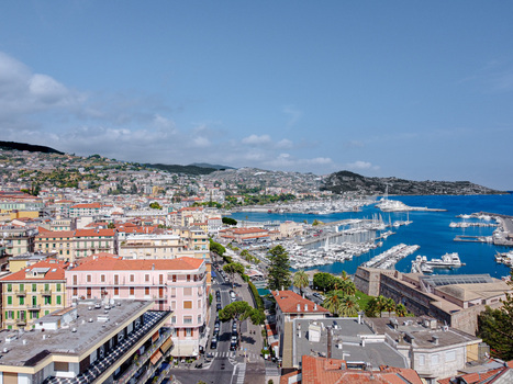Aerial view of Sanremo s harbor filled with yachts colorful Mediterranean buildings and lush green hills under a clear blue sky Sanremo Liguria Italy. Aerial view of Sanremo s harbor filled with yachts colorful Mediterranean buildings and lush green hills under a clear blue sky Sanremo Liguria Italy.