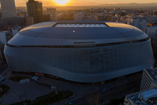 Aerial view of Santiago Bernabeu stadium at sunset with its modern metallic facade and surrounding urban cityscape in Madrid Community of Madrid Spain. Aerial view of Santiago Bernabeu stadium at sunset with its modern metallic facade and surrounding urban cityscape in Madrid Community of Madrid Spain.