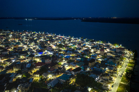 Aerial view of the illuminated streets and buildings of the coastal town at night in Opobo Town Rivers Nigeria. Aerial view of the illuminated streets and buildings of the coastal town at night in Opobo Town Rivers Nigeria.