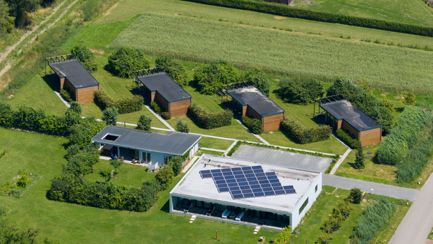 Aerial view of Ecodorp Bolderburen featuring modern wooden houses with solar panels lush green lawns and pathways in Almere Flevoland Netherlands. Aerial view of Ecodorp Bolderburen featuring modern wooden houses with solar panels lush green lawns and pathways in Almere Flevoland Netherlands.