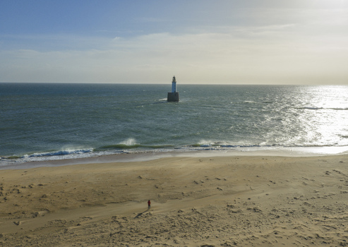 Aerial view of Rattray Head Lighthouse standing in the North Sea with a person on the sandy beach under a bright sky Peterhead Scotland United Kingdom. Aerial view of Rattray Head Lighthouse standing in the North Sea with a person on the sandy beach under a bright sky Peterhead Scotland United Kingdom.
