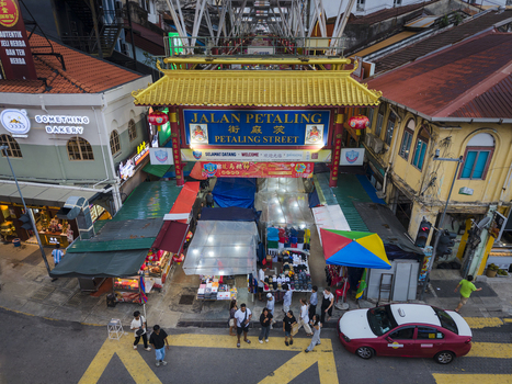 Kuala Lumpur Malaysia 09 March 2026 Aerial view of Petaling Street entrance gate with market stalls colorful umbrellas and people walking on the street.