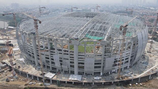 Aerial view of Jakarta International Stadium under construction with towering cranes and intricate steel roof structure in Tanjung Priok Jakarta Indonesia. Aerial view of Jakarta International Stadium under construction with towering cranes and intricate steel roof structure in Tanjung Priok Jakarta Indonesia.