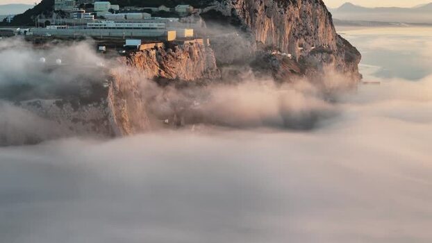 Aerial view of Europa Point rising above sea fog Gibraltar.