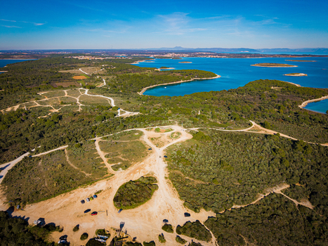 Aerial view of the vibrant contrast between the turquoise Adriatic Sea and the lush green forests of Istria creating a stunning coastal mosaic Kamenjak Istria County Croatia.