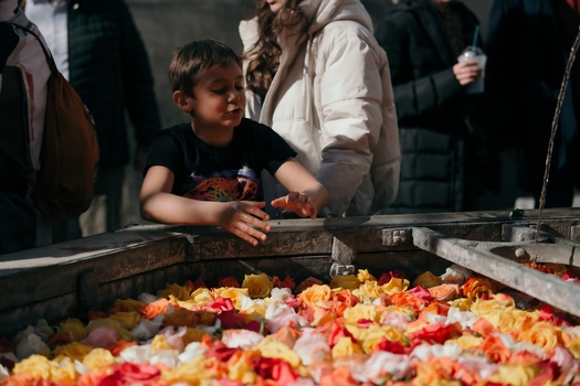 Zurich Switzerland 02 April 2023 View of a young boy reaching into a fountain filled with colorful rose petals at the National Museum Zurich. Zurich Switzerland 02 April 2023 View of a young boy reaching into a fountain filled with colorful rose petals at the National Museum Zurich.
