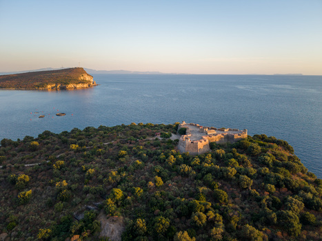 Aerial view of the triangular Porto Palermo Castle surrounded by dense green vegetation and the calm blue waters of the Ionian Sea in Porto Palermo Qarku i Vlores Albania. Aerial view of the triangular Porto Palermo Castle surrounded by dense green vegetation and the calm blue waters of the Ionian Sea in Porto Palermo Qarku i Vlores Albania.
