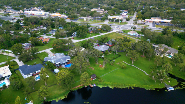 Aerial view of a residential neighborhood with houses swimming pools and lush green lawns situated along a lake in Tampa Florida United States. Aerial view of a residential neighborhood with houses swimming pools and lush green lawns situated along a lake in Tampa Florida United States.