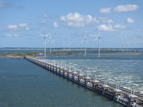 Aerial view of the Eastern Scheldt Storm Surge Barrier with wind turbines and sea water flowing through the gates in Vrouwenpolder Zeeland Netherlands. Aerial view of the Eastern Scheldt Storm Surge Barrier with wind turbines and sea water flowing through the gates in Vrouwenpolder Zeeland Netherlands.