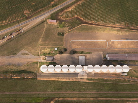 Aerial view of a large grain silo facility with white storage bins surrounded by agricultural fields in Thabo Mofutsanyana District Municipality Free State South Africa. Aerial view of a large grain silo facility with white storage bins surrounded by agricultural fields in Thabo Mofutsanyana District Municipality Free State South Africa.