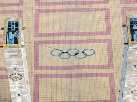Berlin Germany 26 September 2026 Aerial view of the Olympic rings suspended between two stone towers at the Olympiastadion Berlin with the patterned paved plaza visible below.