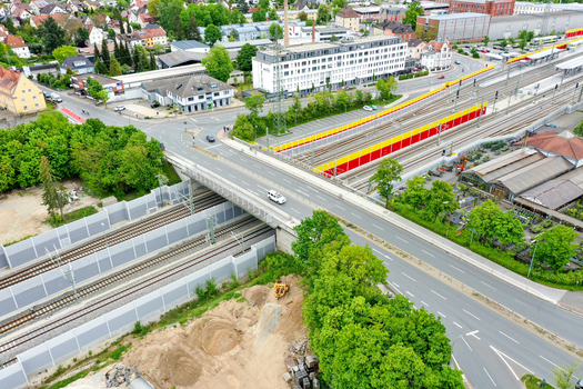 Aerial view of the Bahnhofstrasse bridge crossing over multiple railway tracks surrounded by urban buildings and lush green trees in Forchheim Bayern Germany. Aerial view of the Bahnhofstrasse bridge crossing over multiple railway tracks surrounded by urban buildings and lush green trees in Forchheim Bayern Germany.