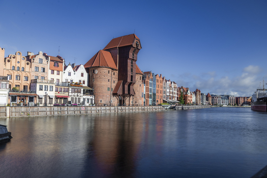 Gdansk Poland 06 September 2026 View of the historic Crane a medieval port crane on the Motlawa River surrounded by colorful merchant houses under a clear blue sky. Gdansk Poland 06 September 2026 View of the historic Crane a medieval port crane on the Motlawa River surrounded by colorful merchant houses under a clear blue sky.
